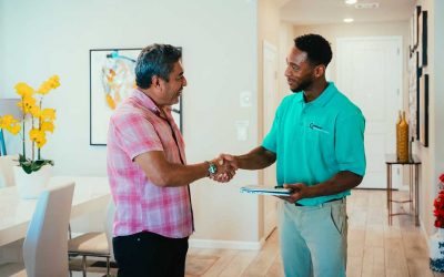 HVAC technician shaking hands with a homeowner in a modern living room